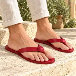 Infradito uomo in pelle rossa - indossati con pantaloni chiari su gradini in pietra