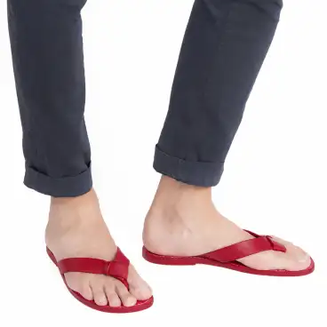 Men's red leather flip-flops - worn with blue trousers against a white background